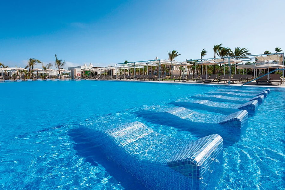 Piscina exterior con tumbonas acuáticas del Hotel Riu Karamboa