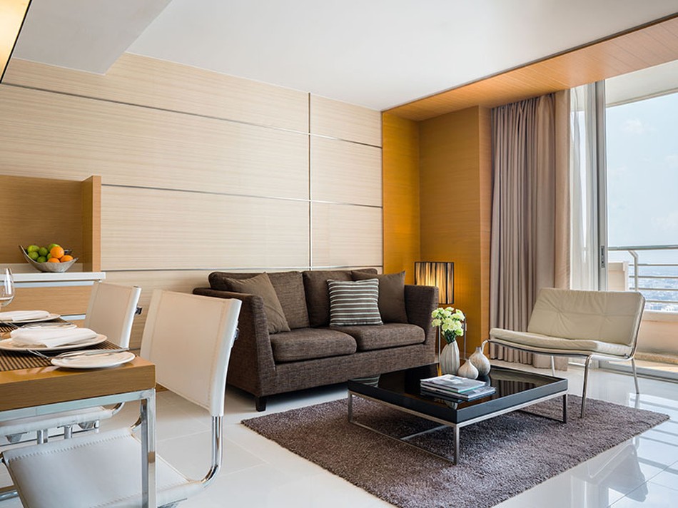Salón con vistas urbanas de la suite de un dormitorio del JC Kevin Sathorn Bangkok Hotel